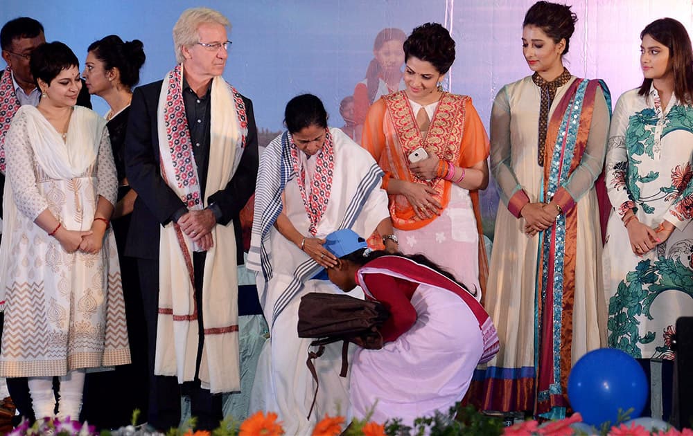 A girl seeks blessing from West Bengal Chief Minister Mamata Banerjee during the launch of Kannyashree Day save girl child celebrations in Kolkata.