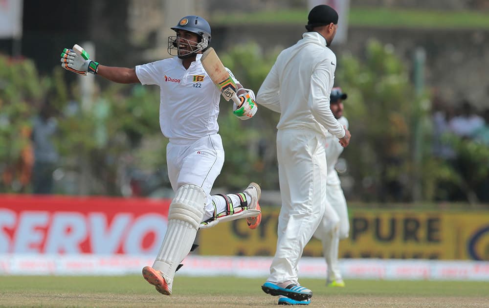 Sri Lanka's Dinesh Chandimal celebrates scoring a century during the third day of the first cricket test match between India and Sri Lanka in Galle, Sri Lanka.