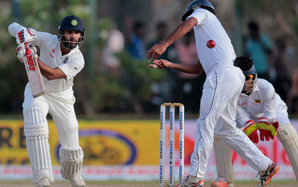 Shikhar Dhawan watches the ball as he plays a shot during the third day of their first cricket test match against Sri Lanka, in Galle, Sri Lanka.