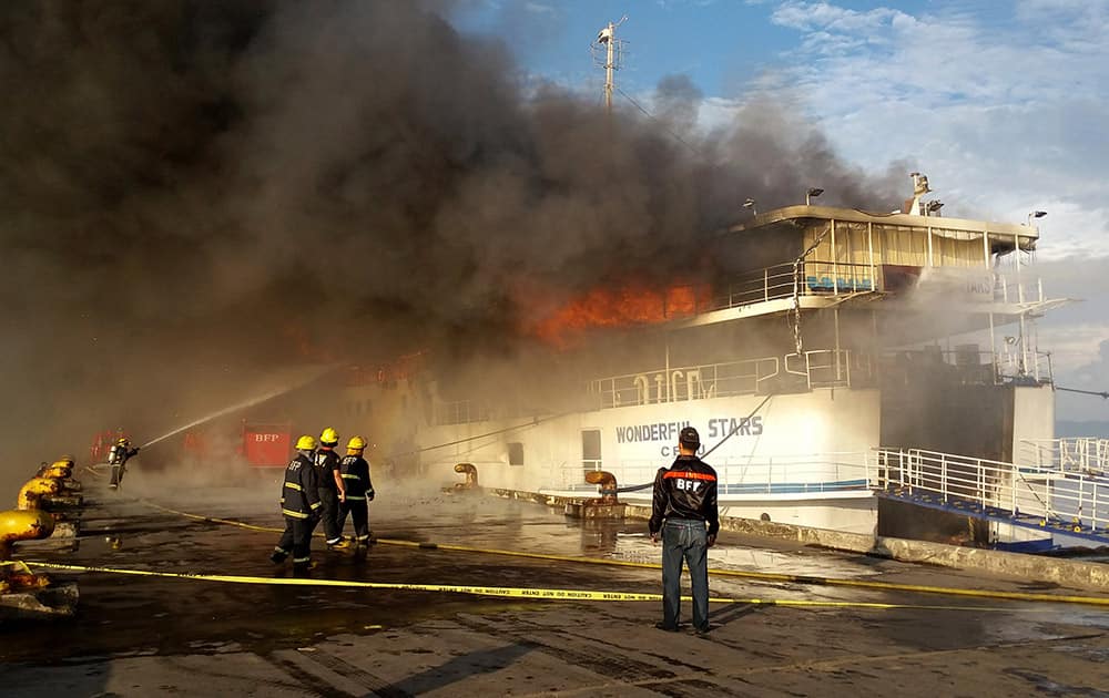 A fireman trains his hose at the burning MV Wonderful Stars ferry which caught fire at the port in Ormoc city in central Philippines.