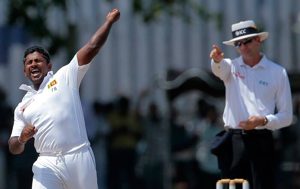 Rangana Herath celebrates the dismissal of India's Ishant Sharma as the umpire signals his decision during the fourth day of their first test cricket match in Galle, Sri Lanka.