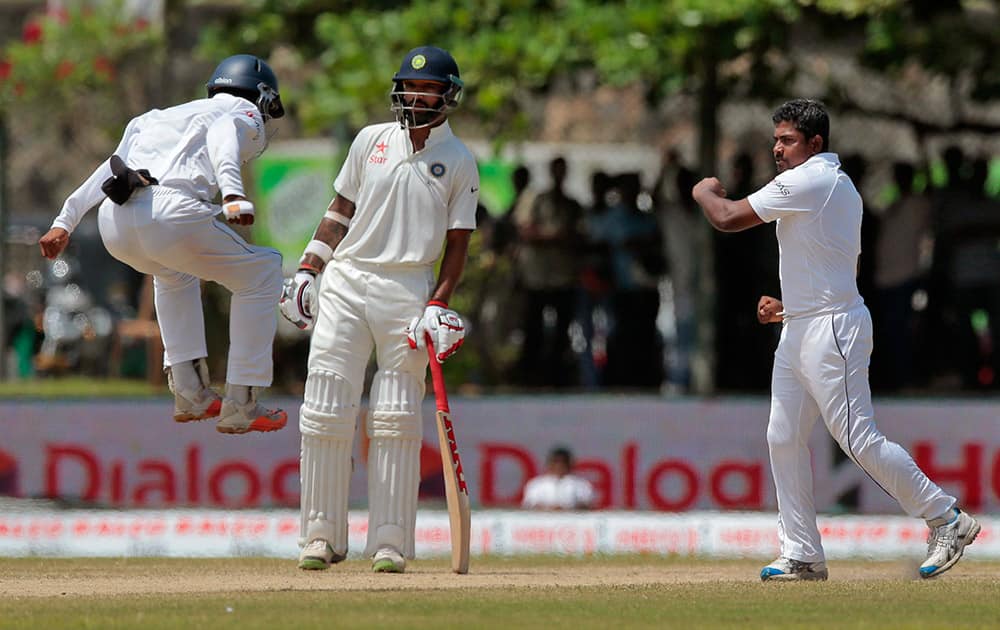 Rangana Herath celebrates the dismissal of India's Rohit Sharma during the fourth day of their first test cricket match in Galle, Sri Lanka.