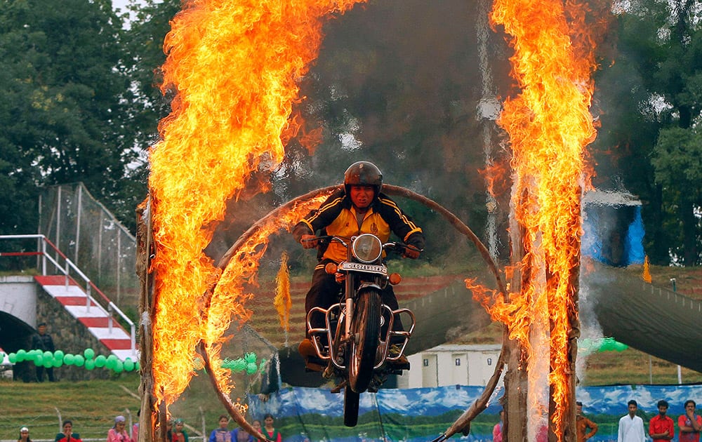 A policeman drives through a burning ring as he performs a daredevil stunt during the 69th Independence Day celebrations in Srinagar.