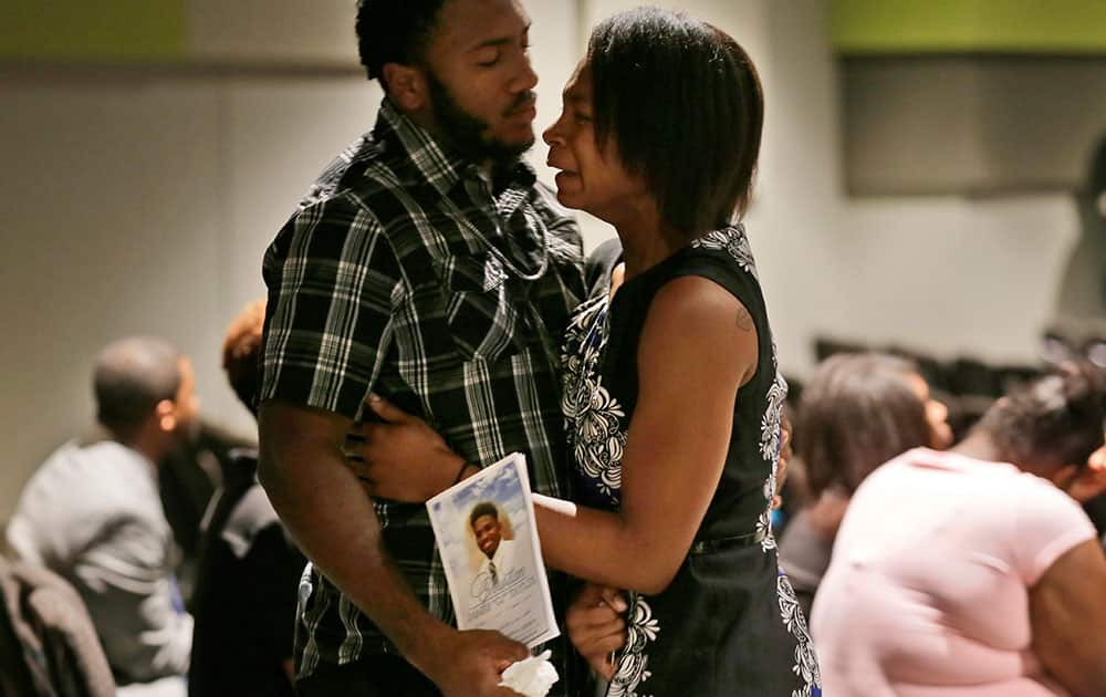 Mourners comfort each other during funeral services for Christian Taylor, 19, at the Koinonia Christian Church in Arlington, Texas.