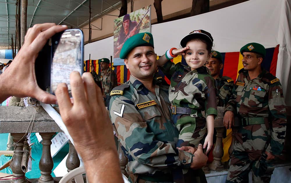 A man takes photographs of a school girl dressed as an army soldier during Indian Army equipment and band display as part of the 69th Independence Day celebrations in Mumbai, India.