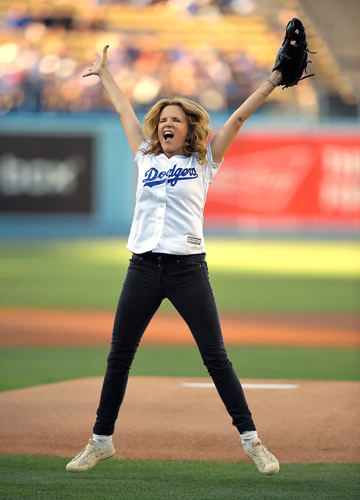 Actress Lea Thompson celebrates after throwing out the ceremonial first pitch prior to a baseball game between the Los Angeles Dodgers and the Cincinnati Reds in Los Angeles.