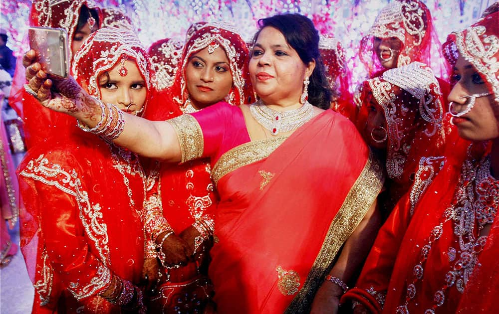 Women clicking selfie with brides during mass marriage ceremony in Mumbai.