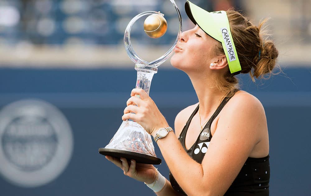 Belinda Bencic, of Switzerland, kisses the winner's trophy after defeating Simona Halep, of Romania, in the women's final at the Rogers Cup tennis tournament.