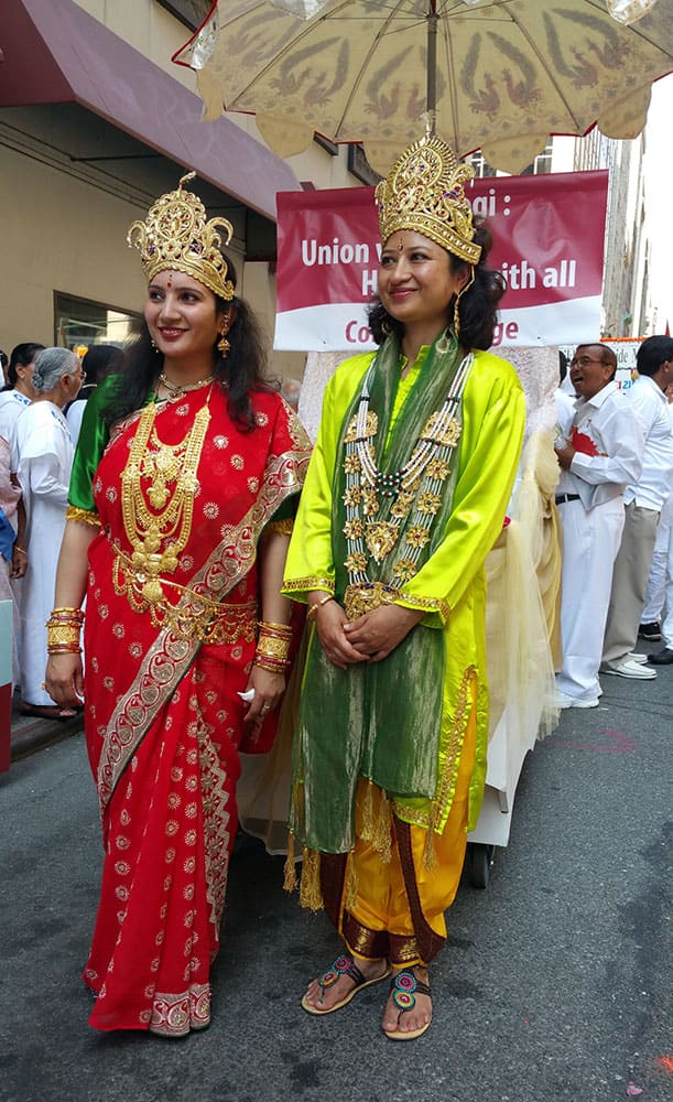 Roshni Patel, left, a medical assistant from Edison, N.J., and Komal Thapa, a teacher from the Brooklyn borough of New York, stand near the float they will ride on at the India Day Parade down New York's Madison Ave.