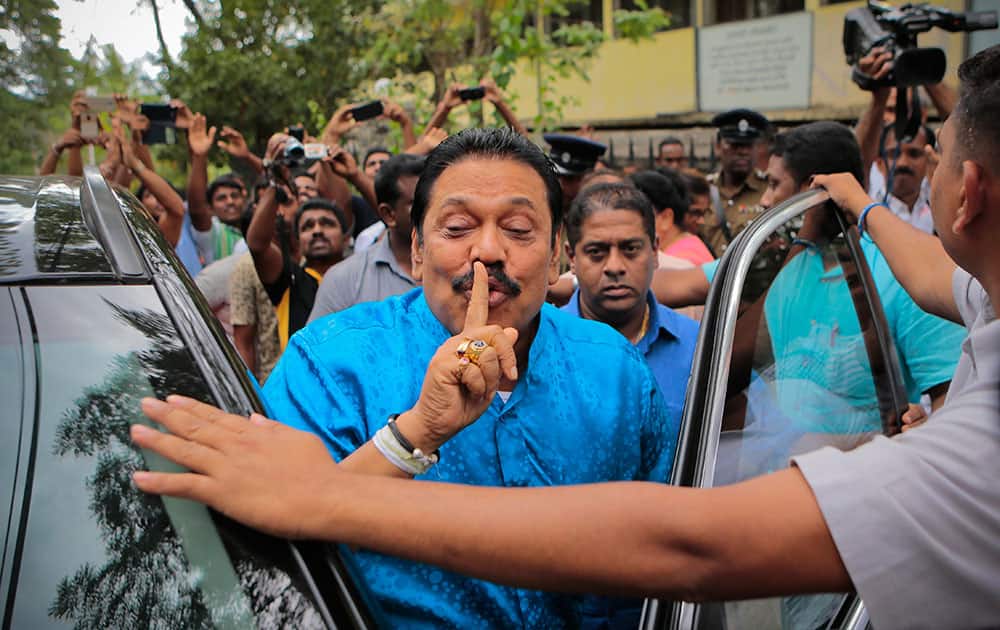 Parliamentary candidate Mahinda Rajapaksa gestures outside a polling station after casting his vote in Medamulana village, southern Sri Lanka.