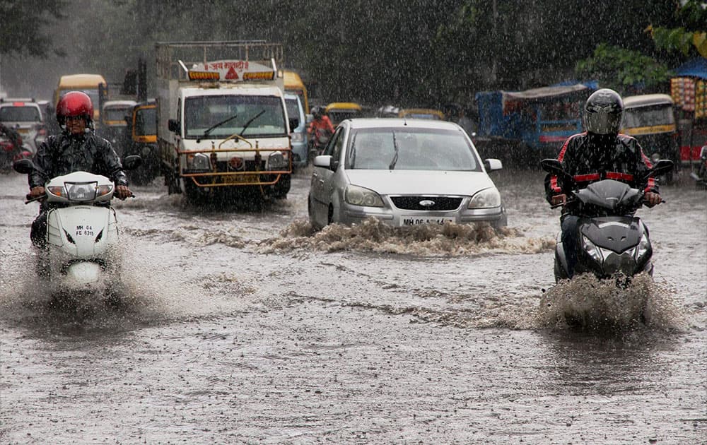 Vehicles wade through a water-logged road due to heavy rains in Thane, Mumbai.