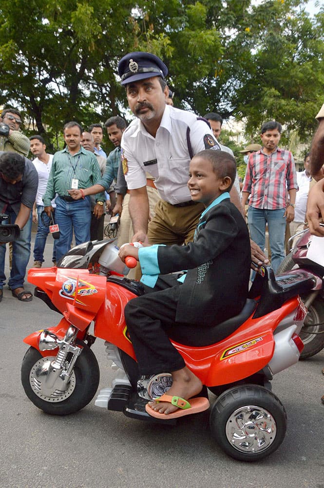 7-yr-old Pavan drives an electronic bike on KBR Park road in Hyderabad on Monday. Hyderabad Traffic Police and Make Wish Foundation fulfill the desire of Pavan, ailing with life threatening medical condition.