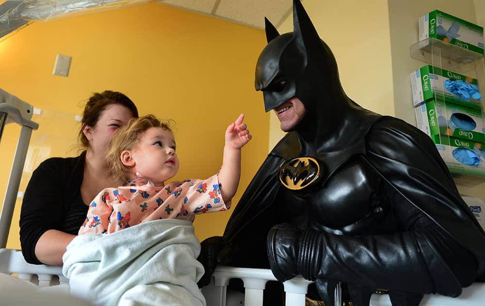 Leonard Robinson, dressed as Batman, visits Mattie Dillon on the pediatrics floor of Charleston Area Medical Center Women and Children's Hospital in Charleston, W.Va. 