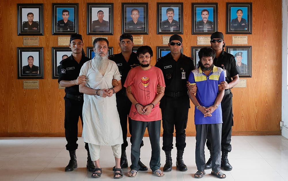 Bangladesh Rapid Action Battalion personnel in black, present before media, suspected members of a banned Islamic militant outfit Ansarullah Bangla Team, Touhidur Rahman, second left, Sadek Ali, center and Aminul Mollick, second right in Dhaka, Bangladesh.