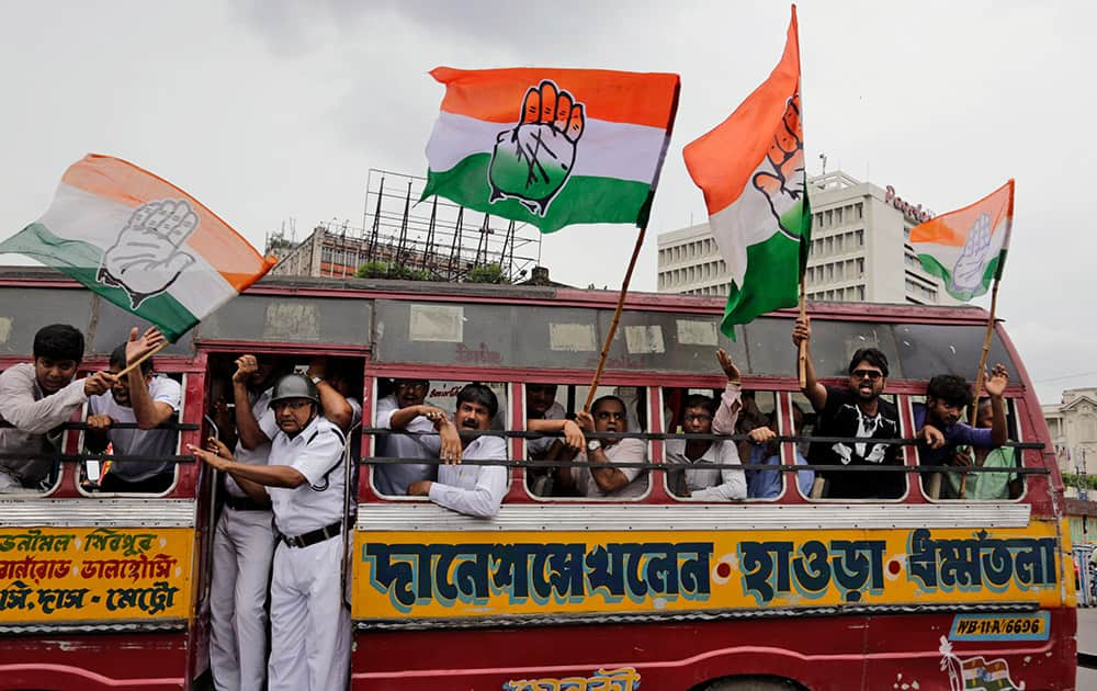 Congress party activists shout slogans from inside a bus after they were detained by policemen during a general strike in Kolkata.