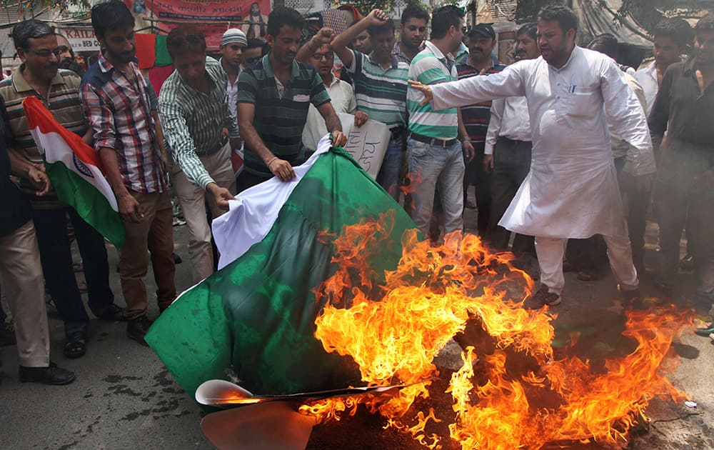 Activists of Jammu and Kashmir National Conference burn a Pakistani flag during a protest against the alleged unprovoked firing by Pakistani troops along the Line of Control (LOC), the line dividing Kashmir between India and Pakistan, in Jammu.