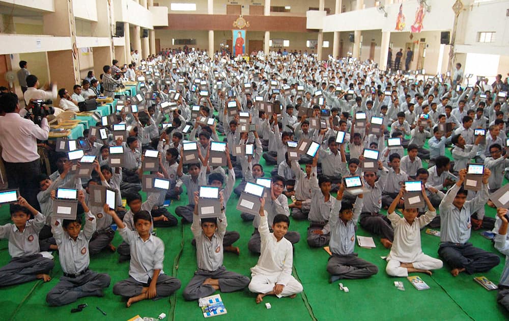 Students showing their Tablet PC presented by school authority under the Prime Ministers ‘Digital India’ programme to reduce the weight of school bags, at a school.