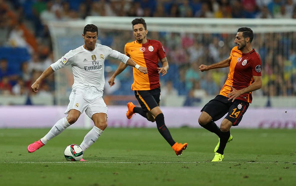 Real Madrids Cristiano Ronaldo, left, tussles for the ball with Galatasarays Jose Rodriguez, right, and Alex Telles during the Santiago Bernabeu trophy soccer match between Real Madrid and Galatasaray at the Santiago Bernabeu Stadium in Madrid.