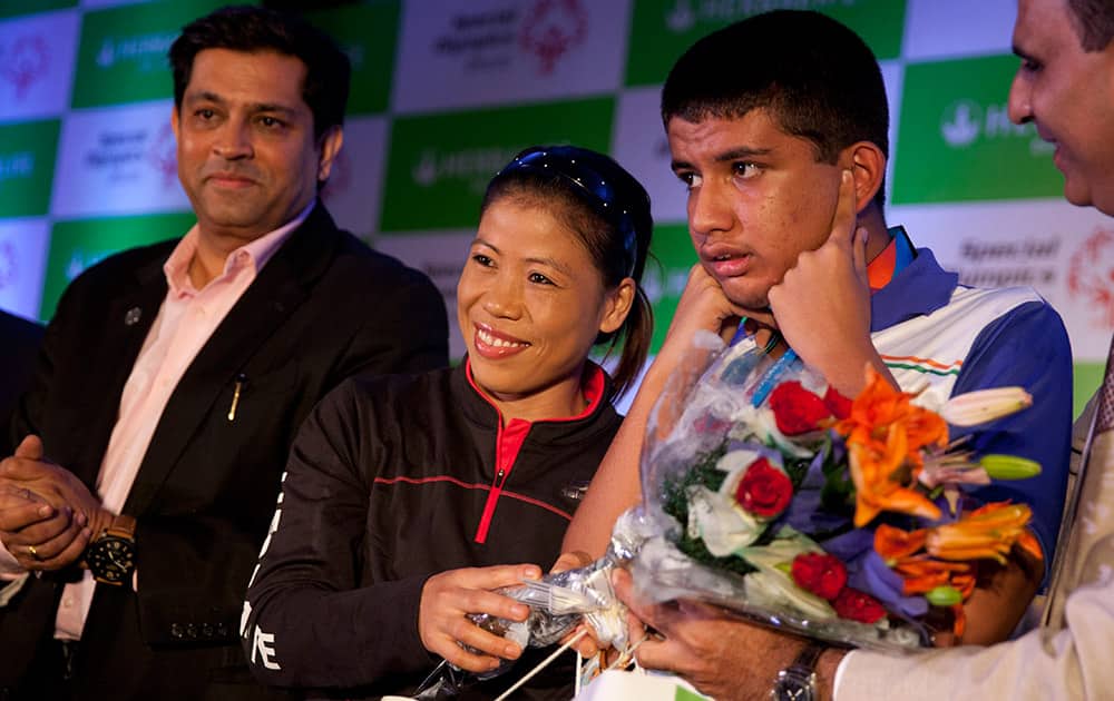 Boxer Mary Kom, felicitates a member, second of the Indian contingent, which returned from the 2015 Special Olympics at an event in New Delhi.