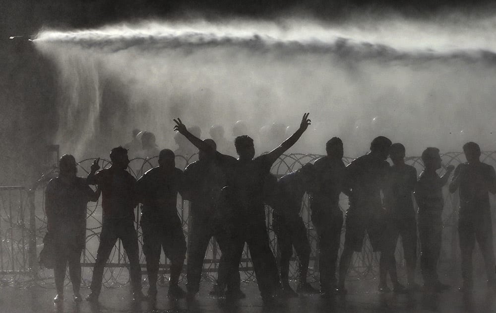 Lebanese activists are sprayed by riot police using water cannons, during a protest against the ongoing trash crisis, in front of the government house, in downtown Beirut, Lebanon.