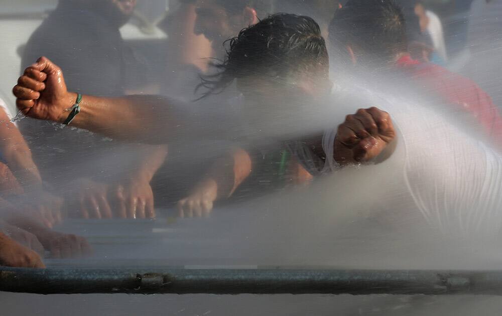 Lebanese activists are sprayed with water as they try to cross to the government house, during a protest against the ongoing trash crisis, in downtown Beirut, Lebanon.