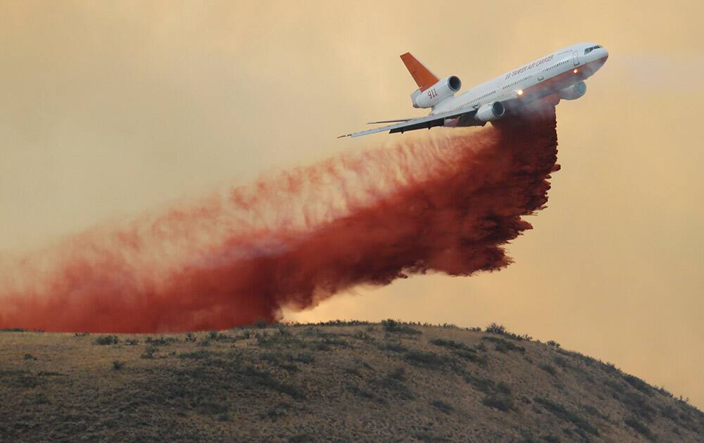 An air tanker drops red fire retardant on a wildfire near Twisp, Wash.