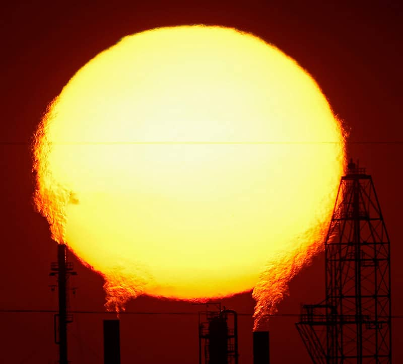 The sun sets behind the National Cooperative Refinery Association oil refinery in McPherson, Kan. 