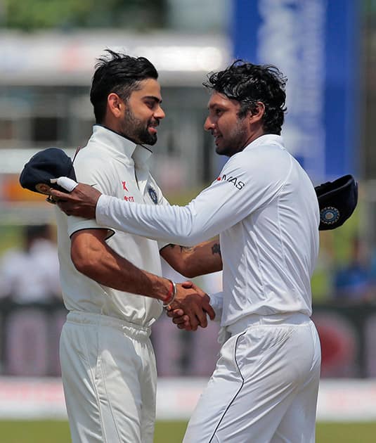 Sri Lanka's Kumar Sangakkara, right, shakes hands with India's captain Virat Kohli after their victory over India during the fourth day of their first test cricket match in Galle, Sri Lanka.