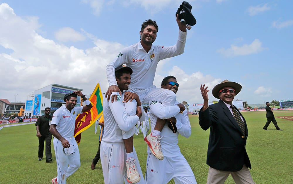 Sri Lankan team members carry Kumar Sangakkara on their shoulders as they walk around the field to celebrate their win over India by 63 runs in their first test cricket match in Galle, Sri Lanka.