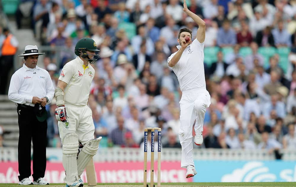 England's Mark Wood bowls to Australia's David Warner watched by Australia's Chris Rogers on the first day of the fifth Ashes Test match between England and Australia, at the Oval cricket ground in London.