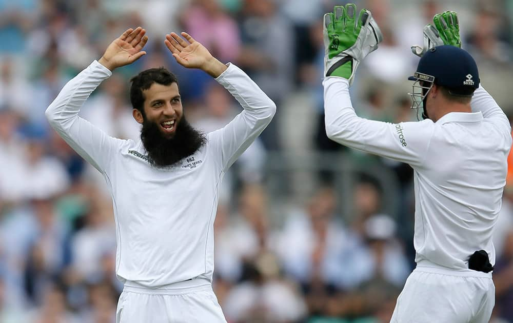 England's Moeen Ali celebrates taking the wicket of Australia's David Warner on the first day of the fifth Ashes Test match between England and Australia, at the Oval cricket ground in London.