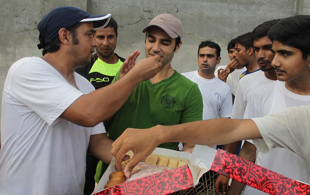 Pakistani cricket fans offer sweets to cricketer Salman Butt in Lahore, Pakistan.