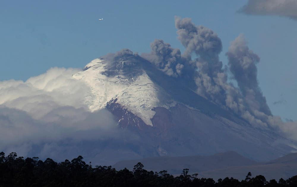 Plumes of smoke and ash billow from the Cotopaxi volcano as seen from Quito, Ecuador.