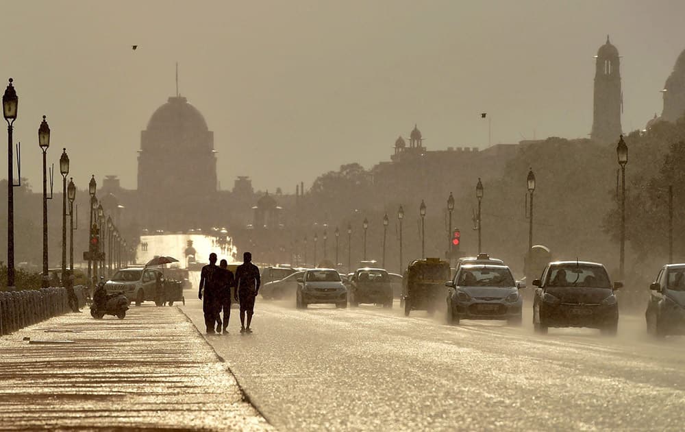 Vehicles move at Rajpath as it rains in New Delhi.