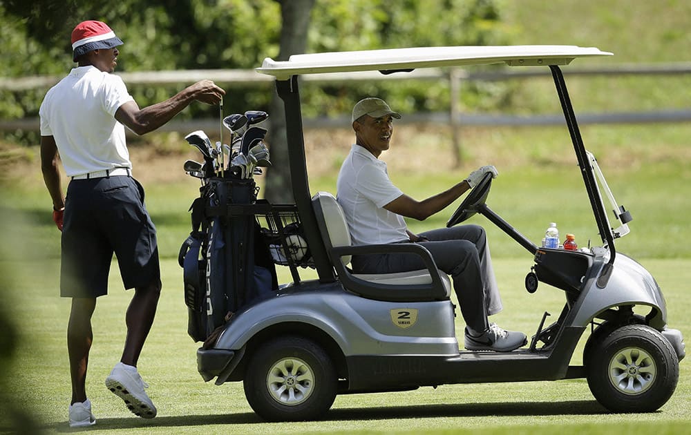 President Barack Obama sits in a golf cart as NBA basketball player Ray Allen selects a club while golfing, at Farm Neck Golf Club, in Oak Bluffs, Mass., on the island of Marthas Vineyard.