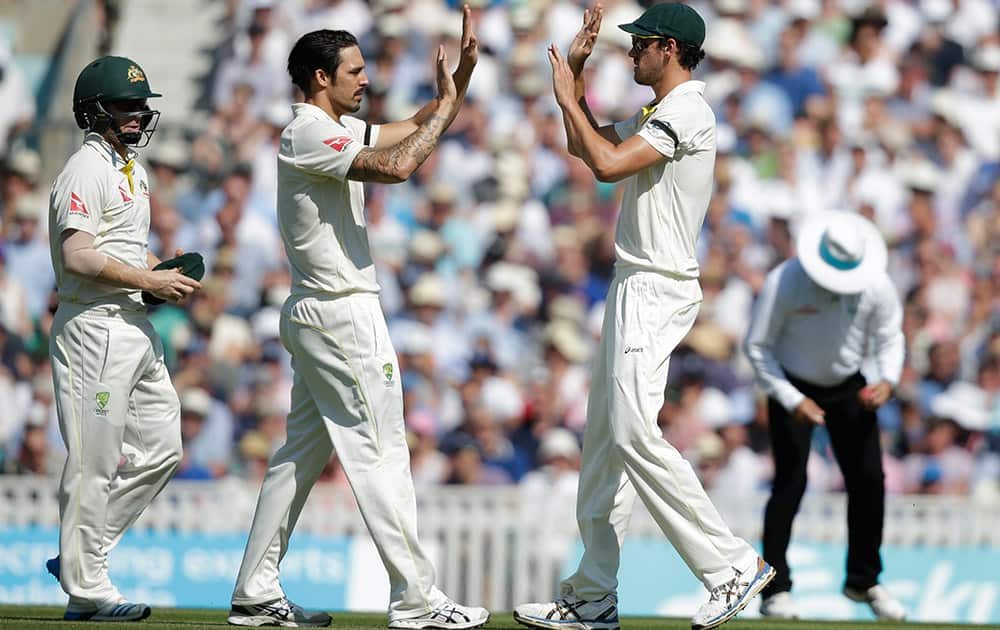 Australia’s Mitchell Starc celebrates with teammate Australia’s Mitchell Johnson after taking a catch to dismiss England’s Mark Wood, off the bowling of Johnson, on the third day of the fifth Ashes cricket test between England and Australia at the Oval cricket ground in London.