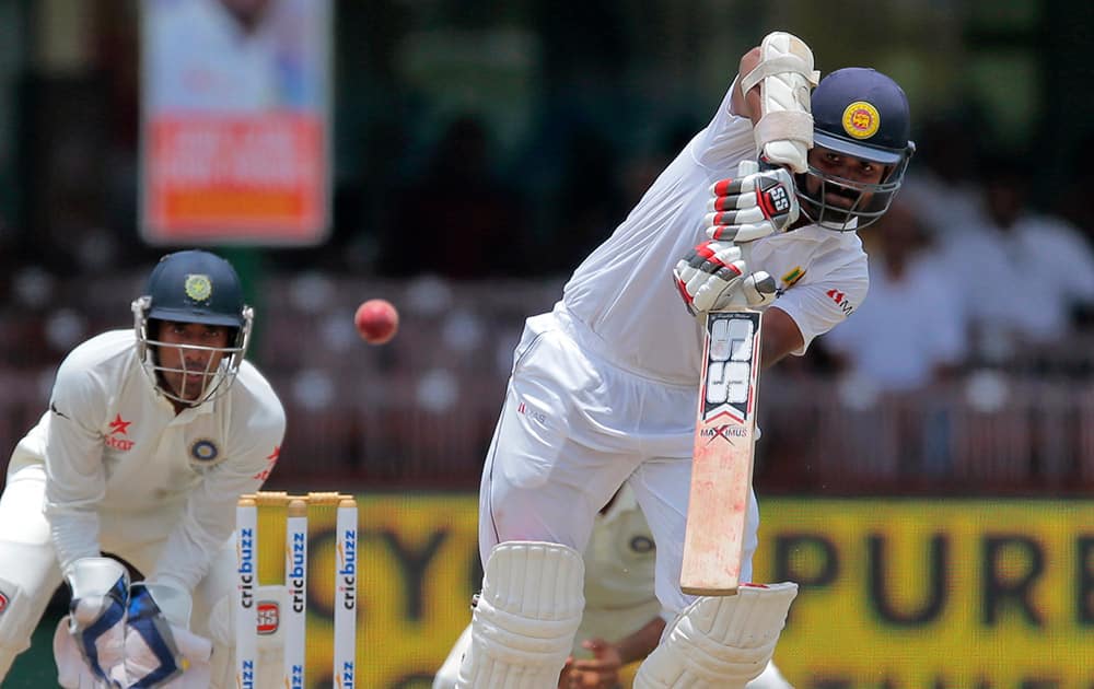 Sri Lanka's Lahiru Thirimanne plays a shot as India's wicketkeeper Wriddhiman Saha watches during the third day's play of the second test cricket match between them in Colombo, Sri Lanka.