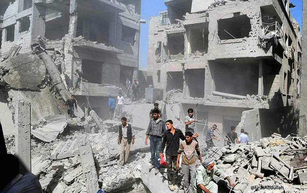 Syrians inspecting damage following a Syrian government airstrike on the Damascus suburb of Douma, Syria.