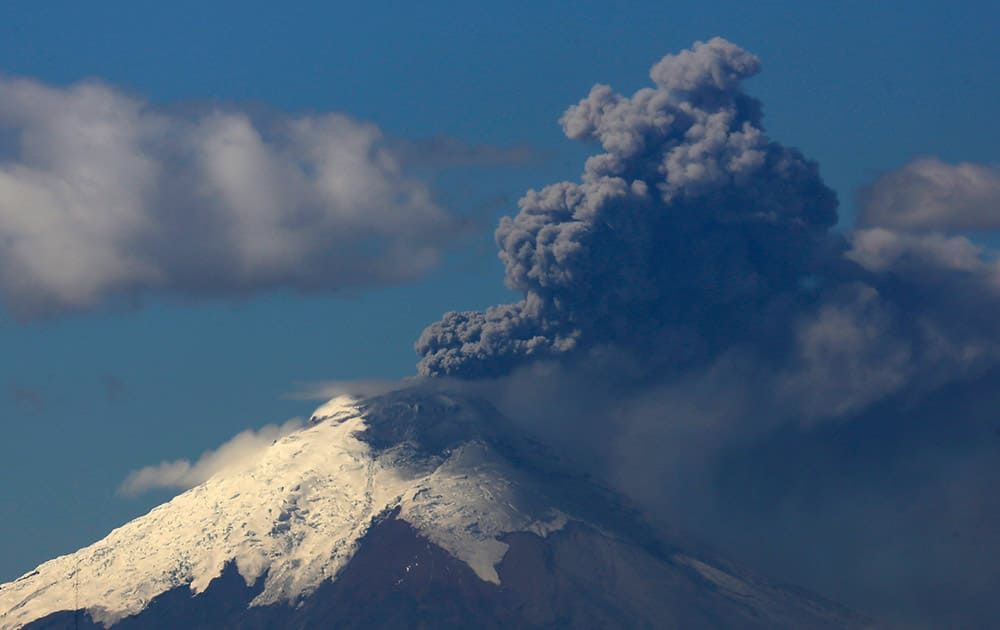 Ash and steam rise from the Cotopaxi volcano as seen from Quito, Ecuador.