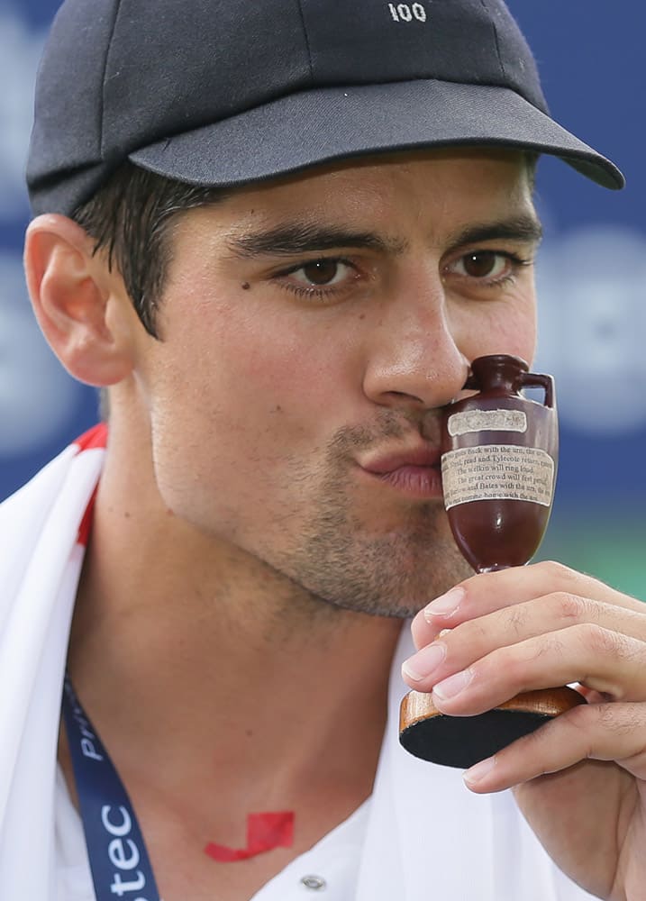 England’s captain Alastair Cook kisses the Ashes Urn as he poses for the media following a presentation ceremony on the forth day of the fifth Ashes cricket test between England and Australia at the Oval cricket ground in London.