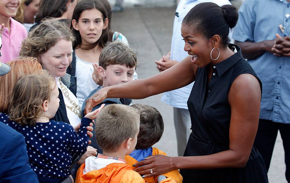 First lady Michelle Obama greets supporters on the tarmac of the Cape Cod Coast Guard Station in Bourne, Mass.