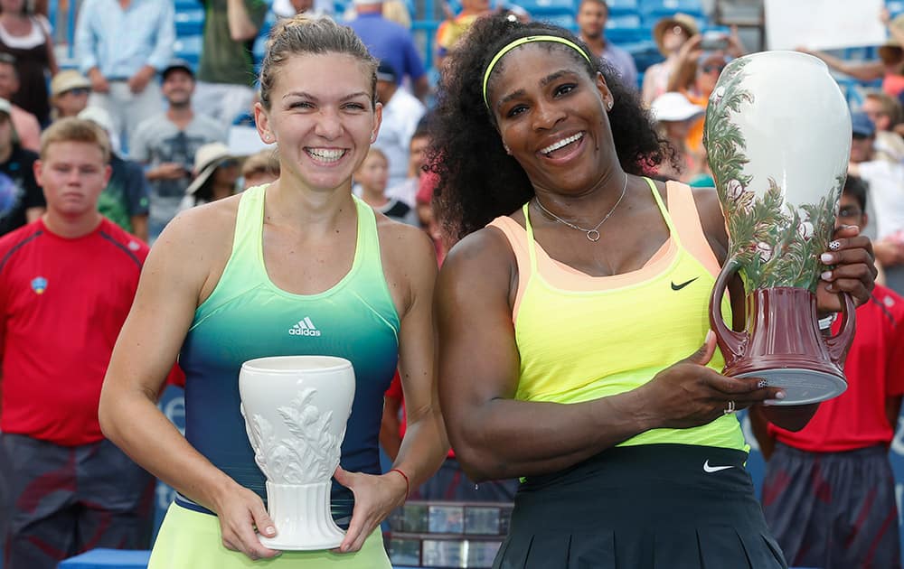 Serena Williams, right, of the United States, holds the Rookwood Cup after defeating Simona Halep, of Romania, left, in the women's final at the Western & Southern Open tennis tournament.