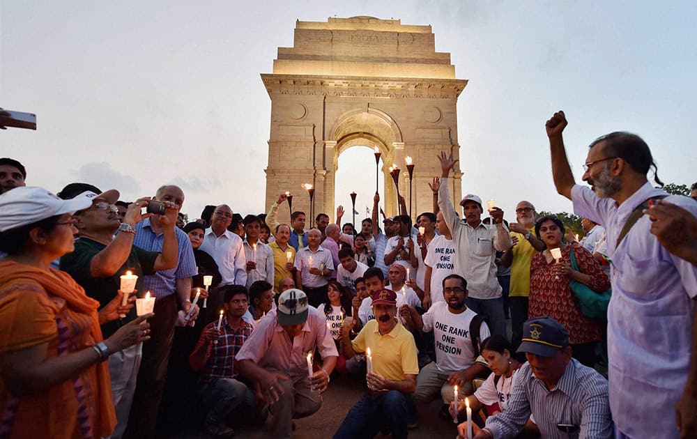 Ex-servicemen participate in the candle light march for One Rank One Pension at India Gate in New Delhi.