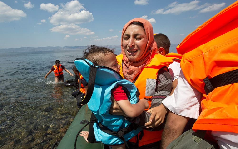 Syrian migrant mother holding her child breaks into tears as they reach the shore of Eftalou beach, 60 kilometers north of the port town of Mytilini after crossing the Aegean from Turkey on the southeastern Greek island of Lesbos, Greece.
