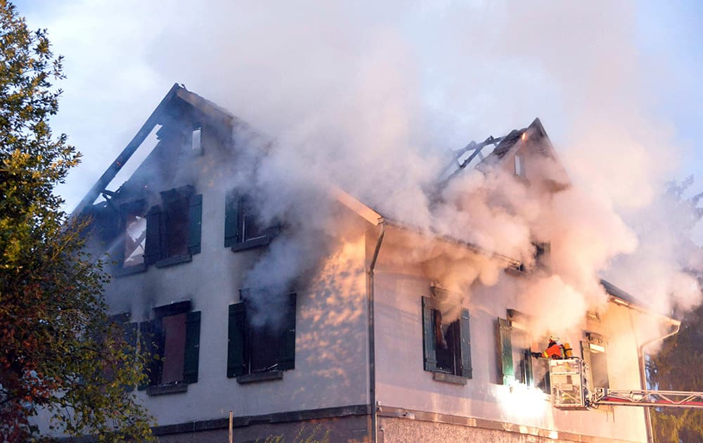 Smoke billows from a burning house that was planned to be converted into a shelter for asylum seekers in Weissach, southern Germany.