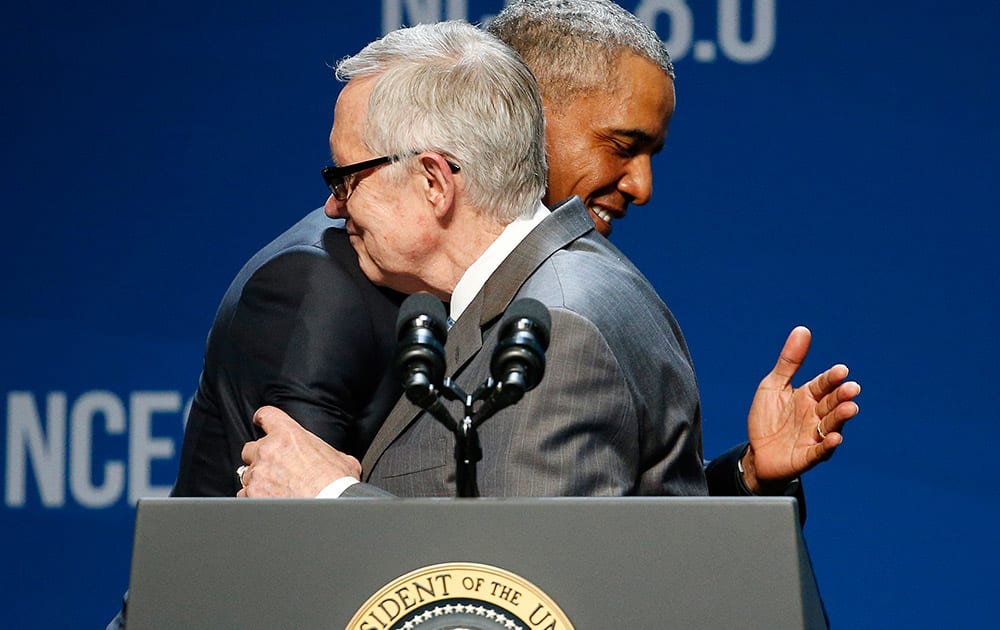 President Barack Obama, right, and Senate Minority Leader Sen. Harry Reid of Nev. embrace on stage at the National Clean Energy Summit in Las Vegas. 