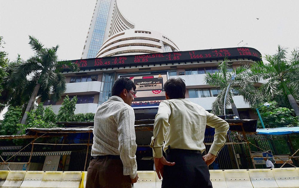 Investors react while watching stock prices at the BSE as the sensex declines by nearly 1500 points in Mumbai.