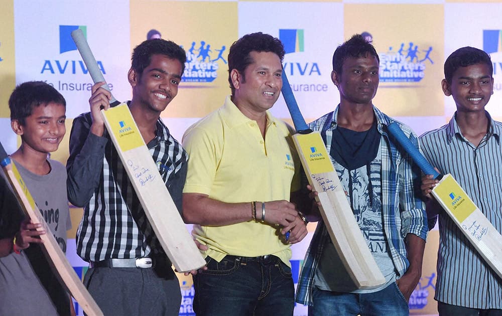 Cricket legend Sachin Tendulkar poses for a photo with the underprivileged children at an event of Avivas Early Starters imitative in Mumbai.