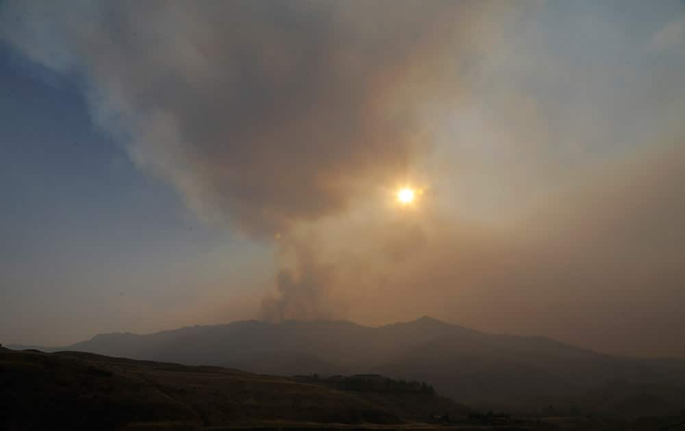 Smoke rises from a ridge above Pateros, Wash., as the sun sets.