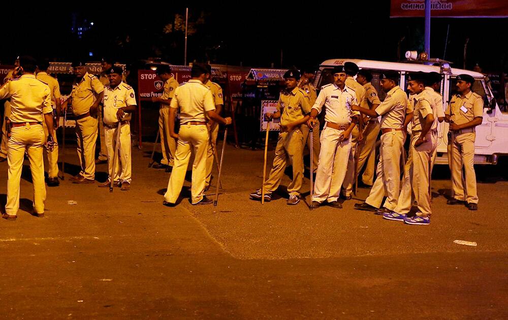 Policemen patrol on a street to nab people damaging vehicles after the arrest of Hardik Patel, convener of Patidar Anamat Andolan Samiti, in Ahmedabad.